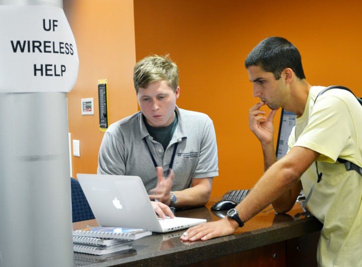 Todd Lowen, a 20-year-old telecommunication sophomore, gets help from Kellen Denny, a Computing Help Desk associate, on Thursday. Lowen had problems with his MacBook’s wireless internet after moving to campus.