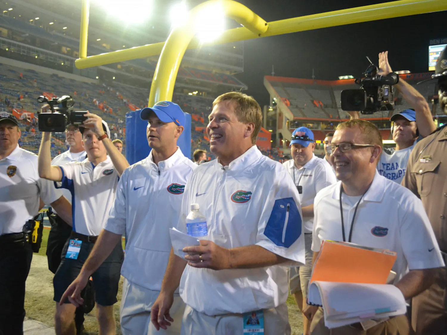 UF head football coach Jim McElwain (center) smiles as he walks off the field at Ben Hill Griffin Stadium following Florida's 61-13 win against New Mexico State Sept. 5, 2015