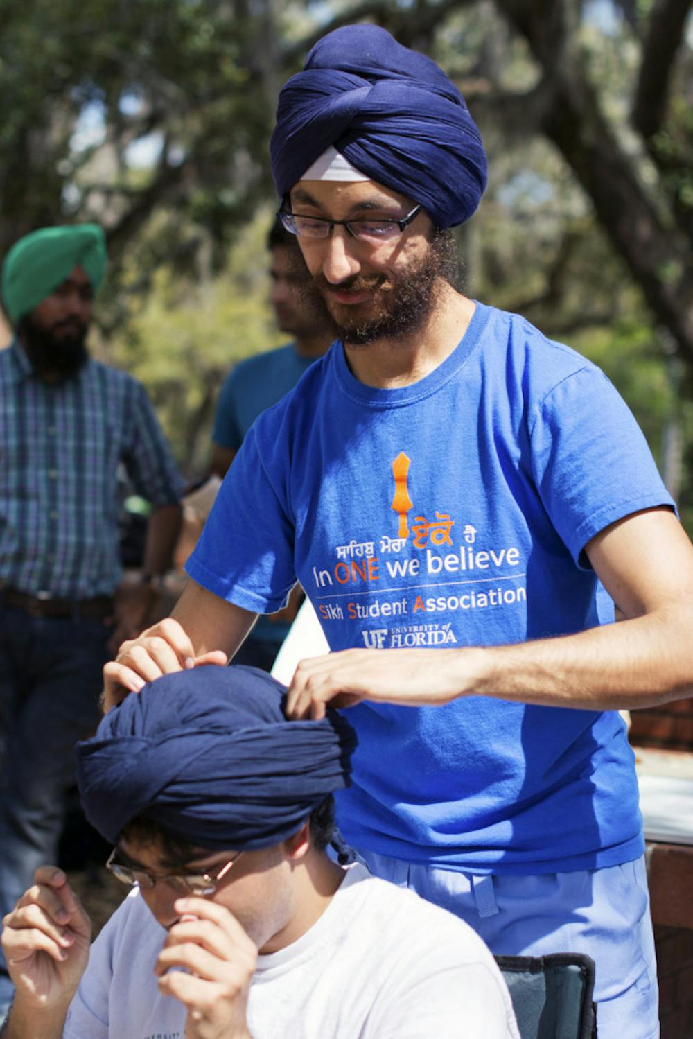 <p>Neal Singh, 24, a second-year dental student wraps Narayan Kulkarni's head in a Sikh turban as part of the Sikh Students Association bi-annual Turban Day.</p>