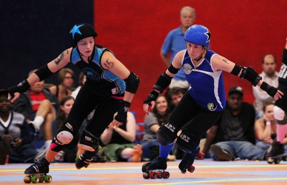 <p>Lady Rider from the Blue Ridge Rollergirls and LeBrawn Maimes from the Gainesville Roller Rebels, both jammers, race across the rink. Identified by stars on their helmets, jammers are the only players who can score points for the team.</p>