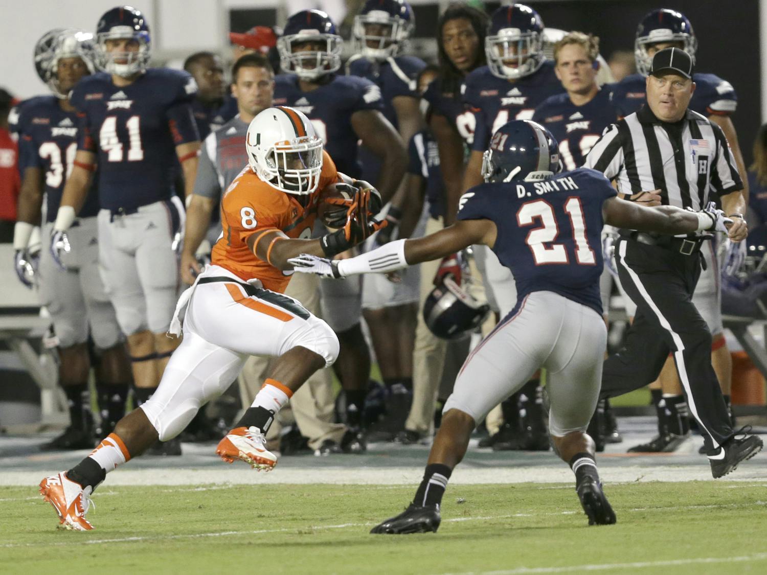 Miami running back Duke Johnson (8) attempts to avoid Florida Atlantic defensive back D’Joun Smith during the first half of an NCAA college football game on Aug. 30, in Miami Gardens, Fla. Johnson had a career-high 186 rushing yards and a touchdown as Miami defeated Florida Atlantic 34-6.