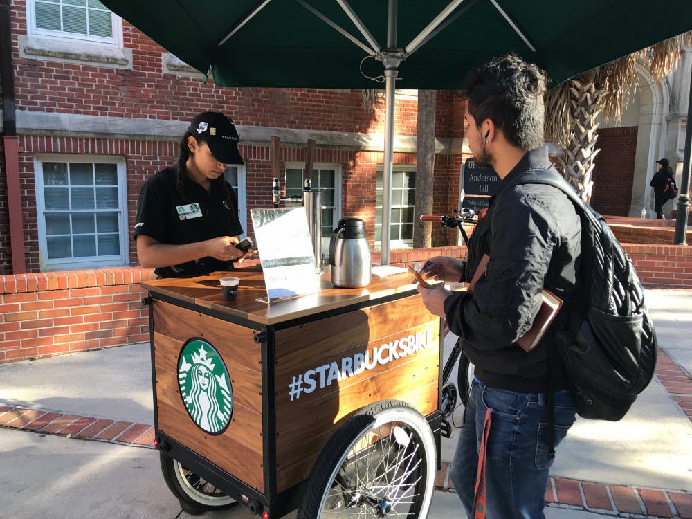 Irfan Kovankaya, a 21-year-old UF political science junior, stops by the #StarbucksBIKE to buy a cup of nitro cold brew coffee before class. 