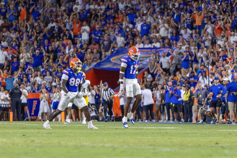 Redshirt freshman lineman Caleb Banks (88) and redshirt sophomore linebacker Scooby Williams (17) celebrate a defensive play in the Gators’ 49-7 win against the McNeese State Cowboys Saturday, Sept. 9 2023.