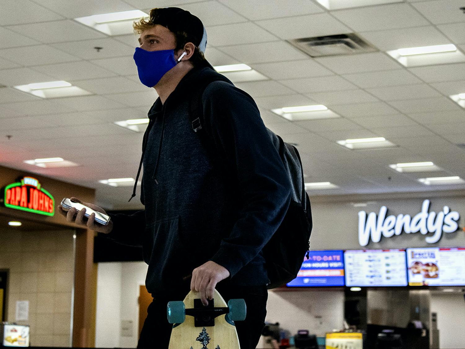 Broc Bohne, 19, UF biology freshman, walks past a Papa John’s and Wendy’s in the J. Wayne Reitz Union food court on Tuesday, Jan. 19, 2021.