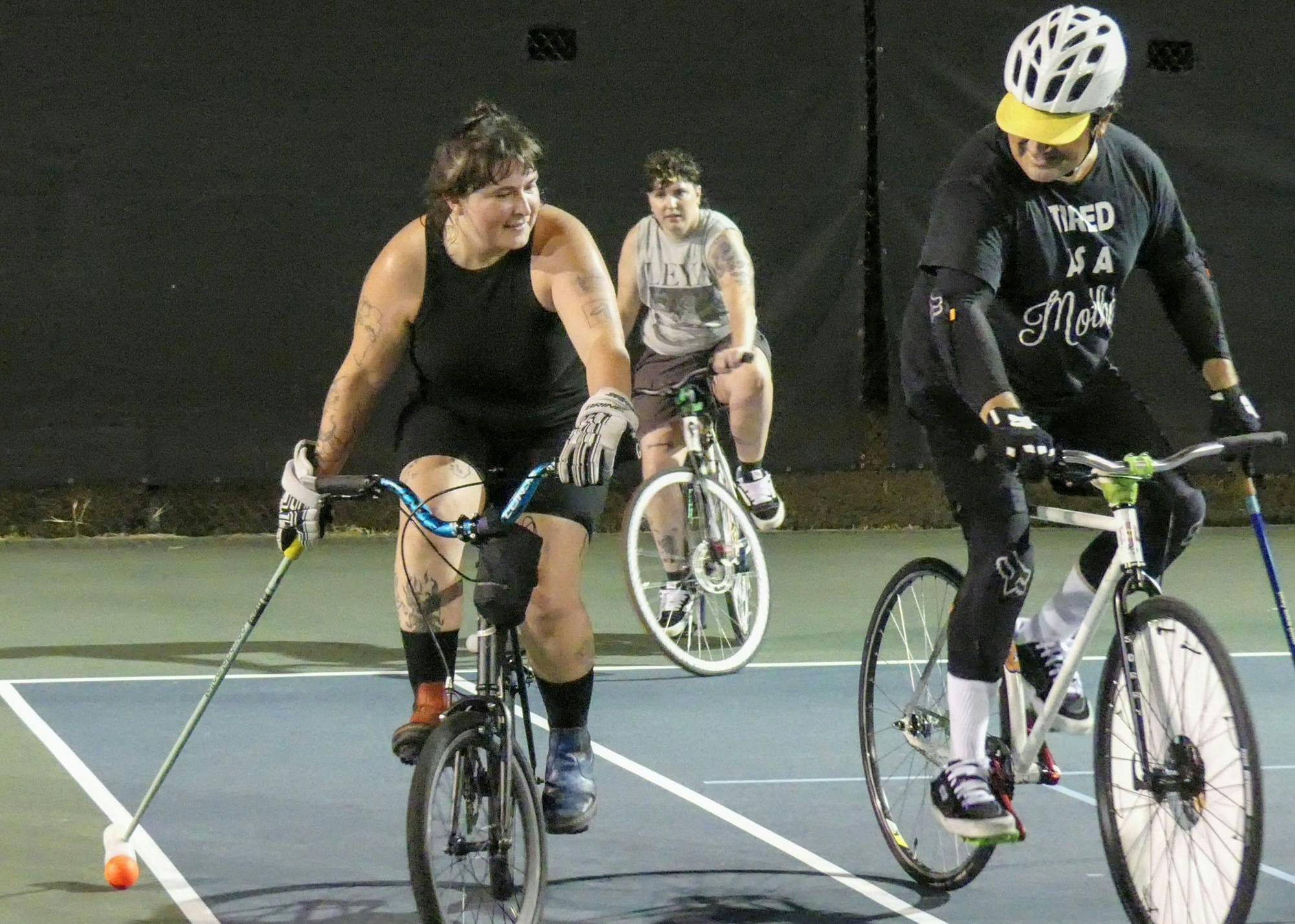 Holding mallets in one hand and balancing with the other, members of the Gainesville Bike Polo Allstars practice their skills in a head-to-head match Thursday, Aug. 28, 2025.