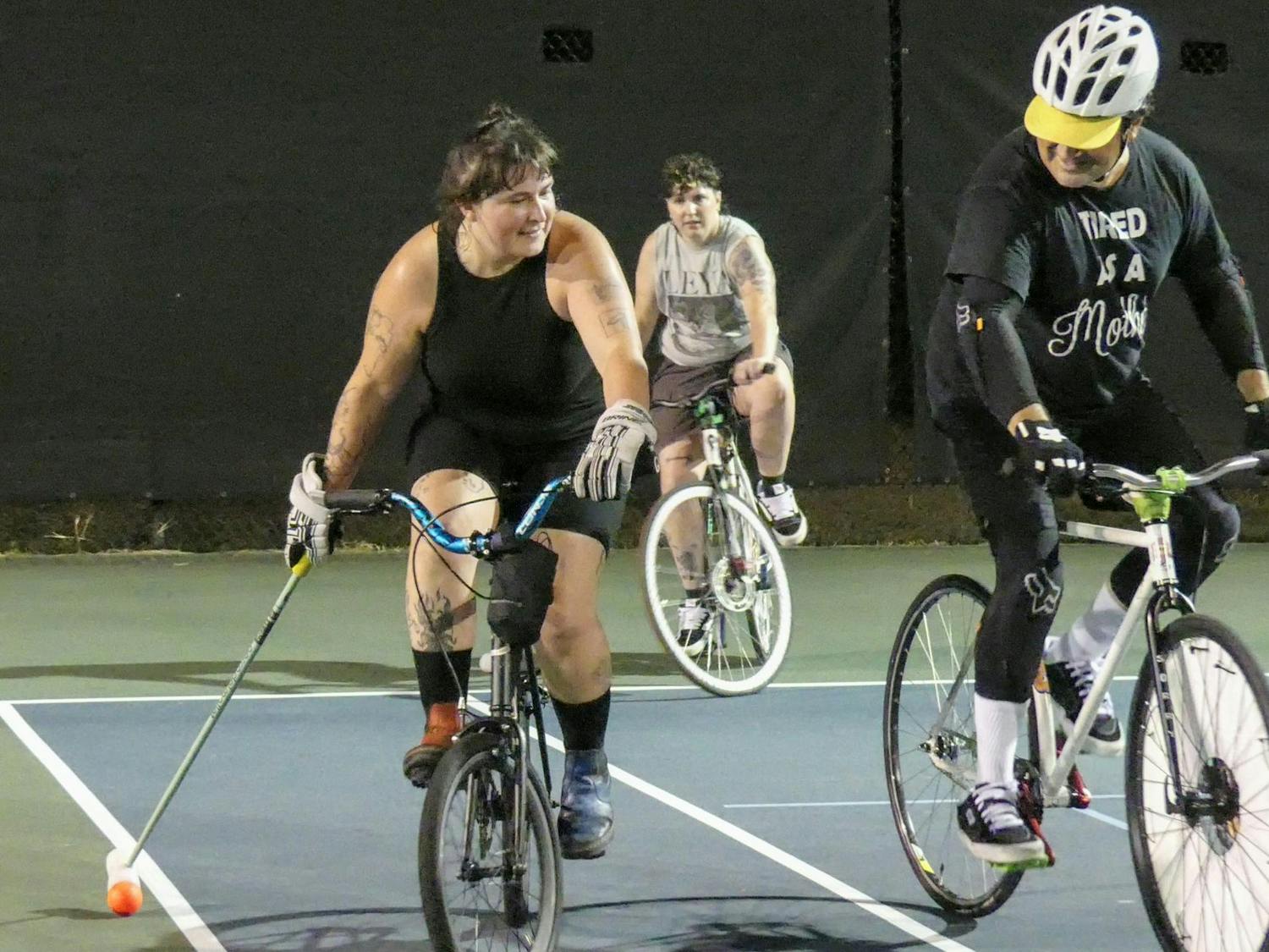 Holding mallets in one hand and balancing with the other, members of the Gainesville Bike Polo Allstars practice their skills in a head-to-head match Thursday, Aug. 28, 2025.