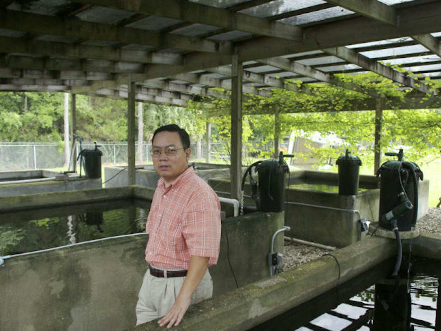 Peter Jiang, an entomologist with Gainesville Mosquito Control, stands next to the service’s stock of mosquito fish. The fish are used as a natural means of killing mosquito larvae.