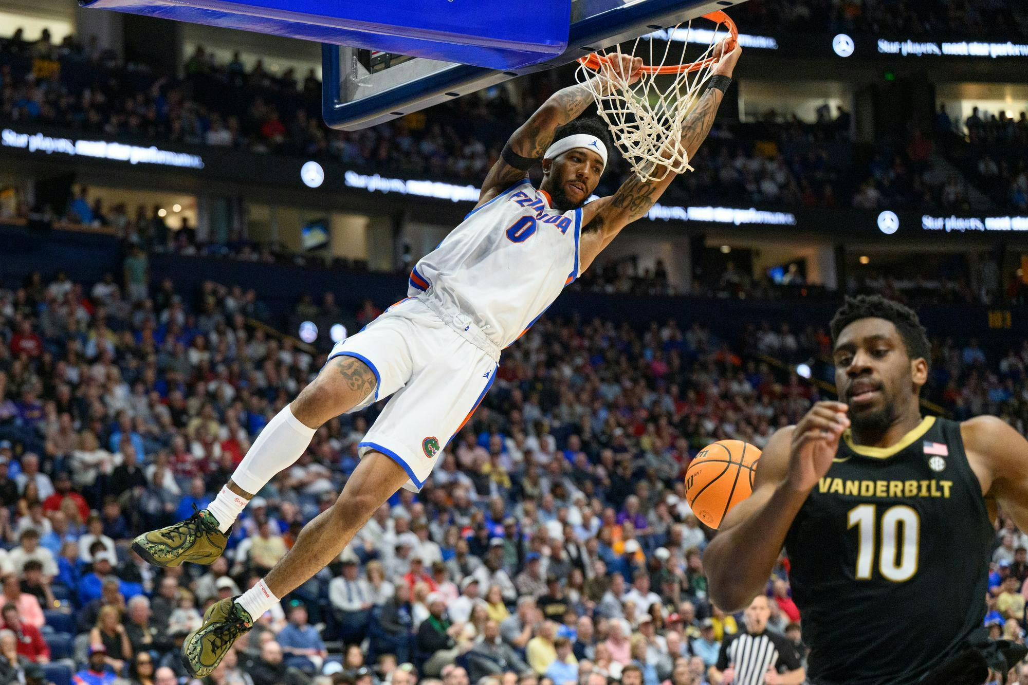 Florida guard Boogie Fland (0) hangs on the rim during the second half of an SEC Men's Basketball Tournament semifinal game against Vanderbilt, Saturday, March 14, 2026, in Nashville, Tenn.