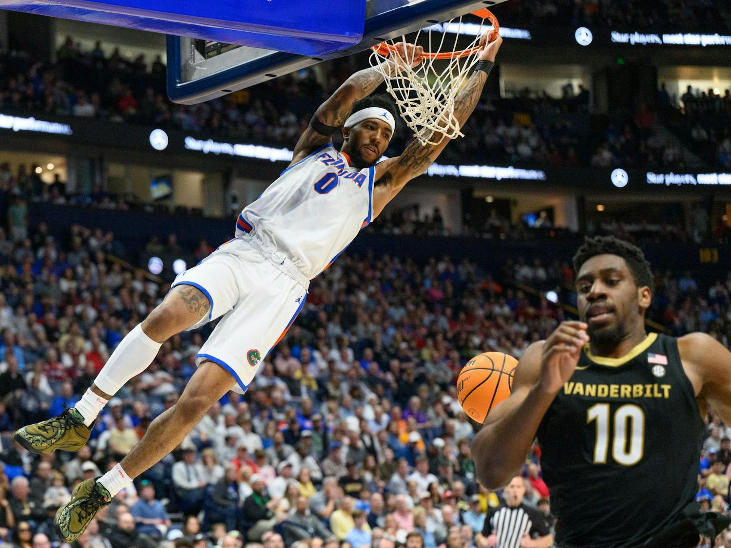 Florida guard Boogie Fland (0) hangs on the rim during the second half of an SEC Men's Basketball Tournament semifinal game against Vanderbilt, Saturday, March 14, 2026, in Nashville, Tenn.