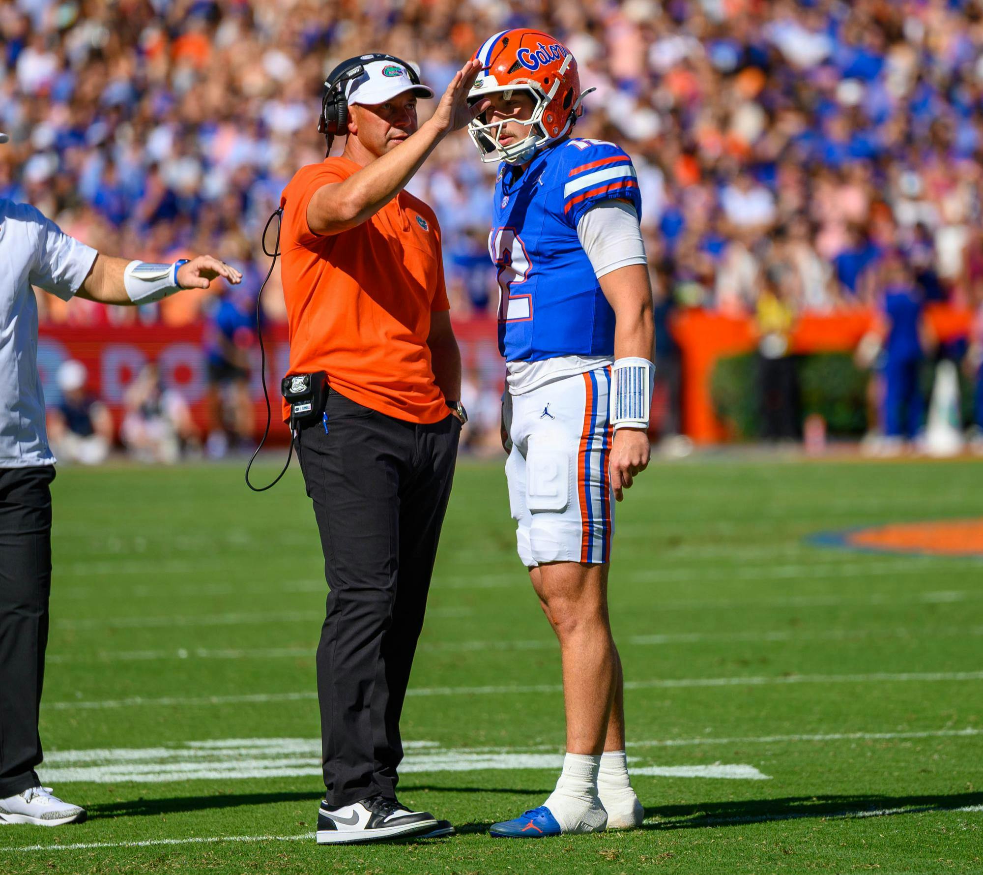 Florida head coach Jon Sumrall speaks with quarterback Aaron Philo (12) during a timeout in  the first half of an NCAA college football game against Ole Miss, Saturday, Sept. 26, 2026, in Gainesville, Fla.