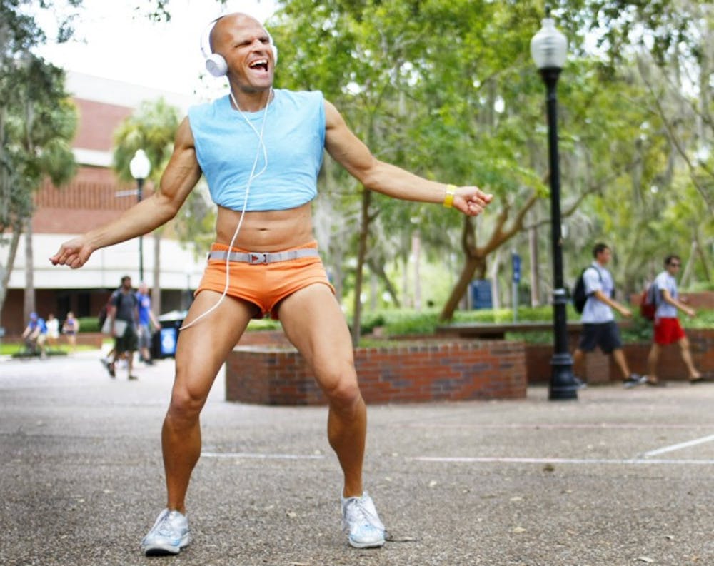 <p>Dennis Kane, 36, dances on Turlington Plaza on Wednesday afternoon. From 9 a.m. to 3 p.m. students can catch Kane waving his arms while listening to music on the plaza.</p>
