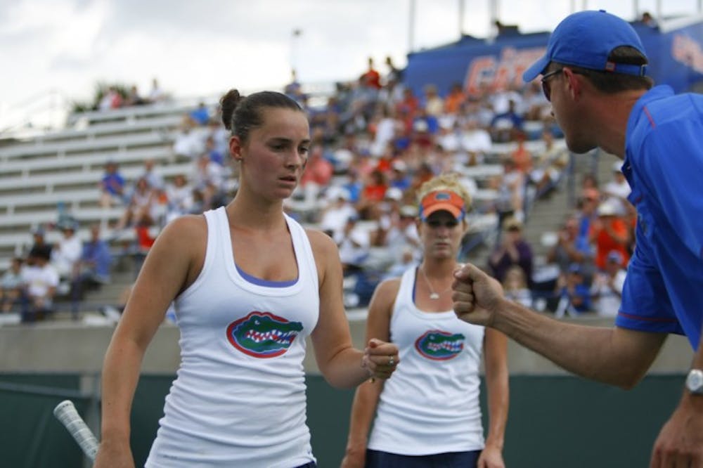 <p>Florida coach Roland Thornqvist (right) congratulates junior Sofie Oyen (left) and former Gator Allie Will (back) during a match against Duke on March 14, 2012.&nbsp;</p>