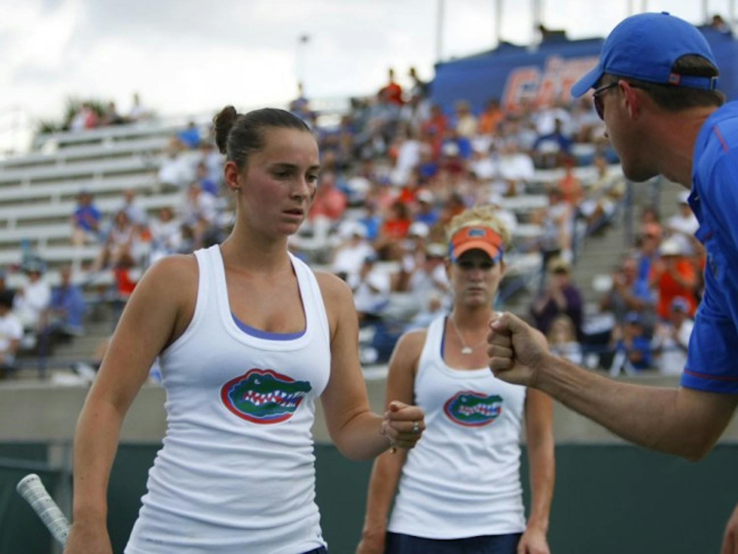 Florida coach Roland Thornqvist (right) congratulates junior Sofie Oyen (left) and former Gator Allie Will (back) during a match against Duke on March 14, 2012.&nbsp;
