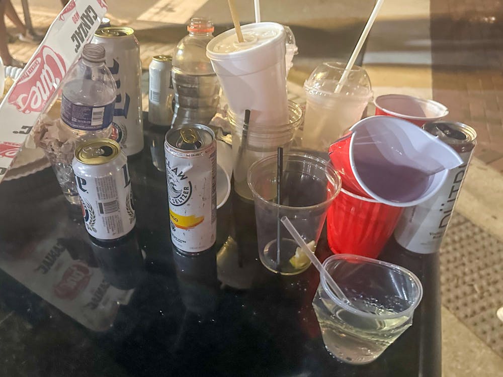 Cups and cans are seen on the top of an overfilled trash can on the corner of NW 17th St and NW 1st Ave on Saturday, Aug. 31.