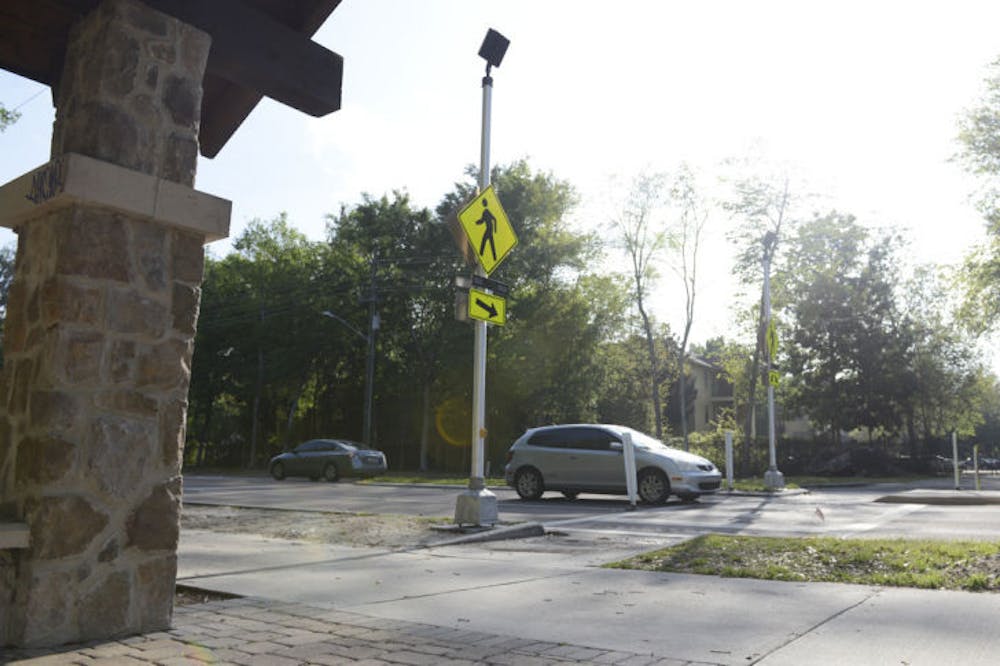 <p>Newly installed flashing light signs are seen at the crosswalk on Southwest 62nd Boulevard. The signs alert drivers of crossing pedestrians.</p>