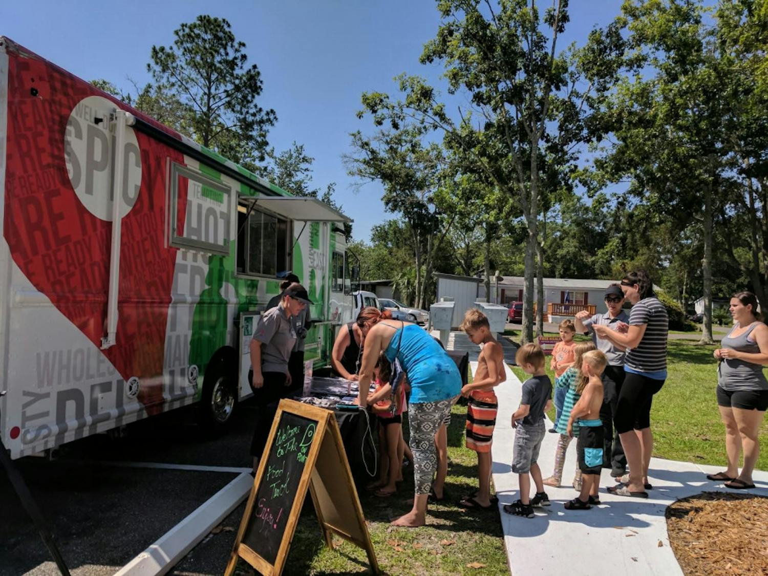 People line up in front of the Alachua County Public Schools On Point Food Truck in Gainesville for the Summer BreakSpot Program.