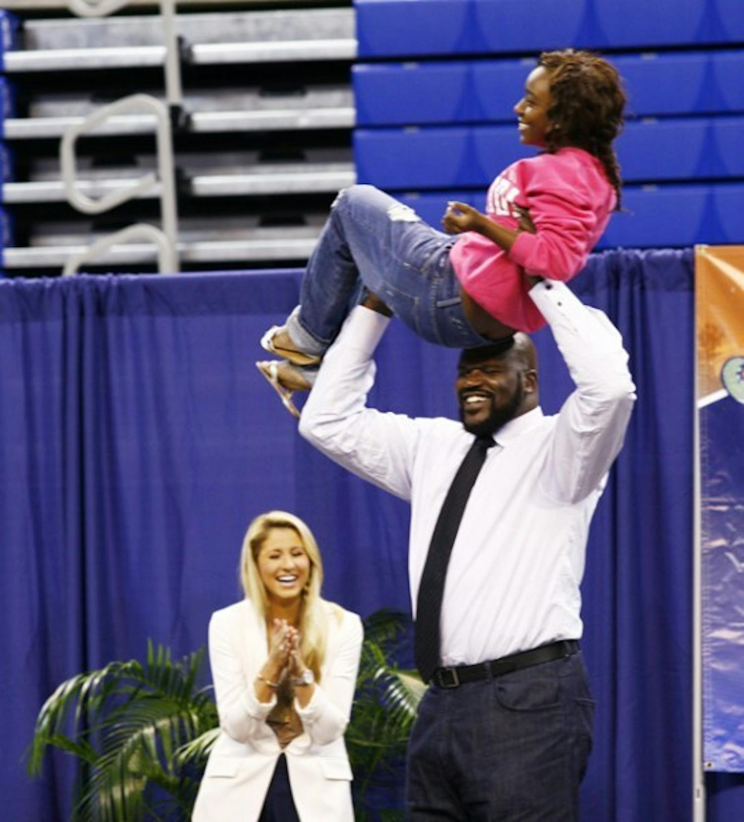 Shaquille O'Neal lifts an audience member in celebration after she was crowned the "Dougie" champion.