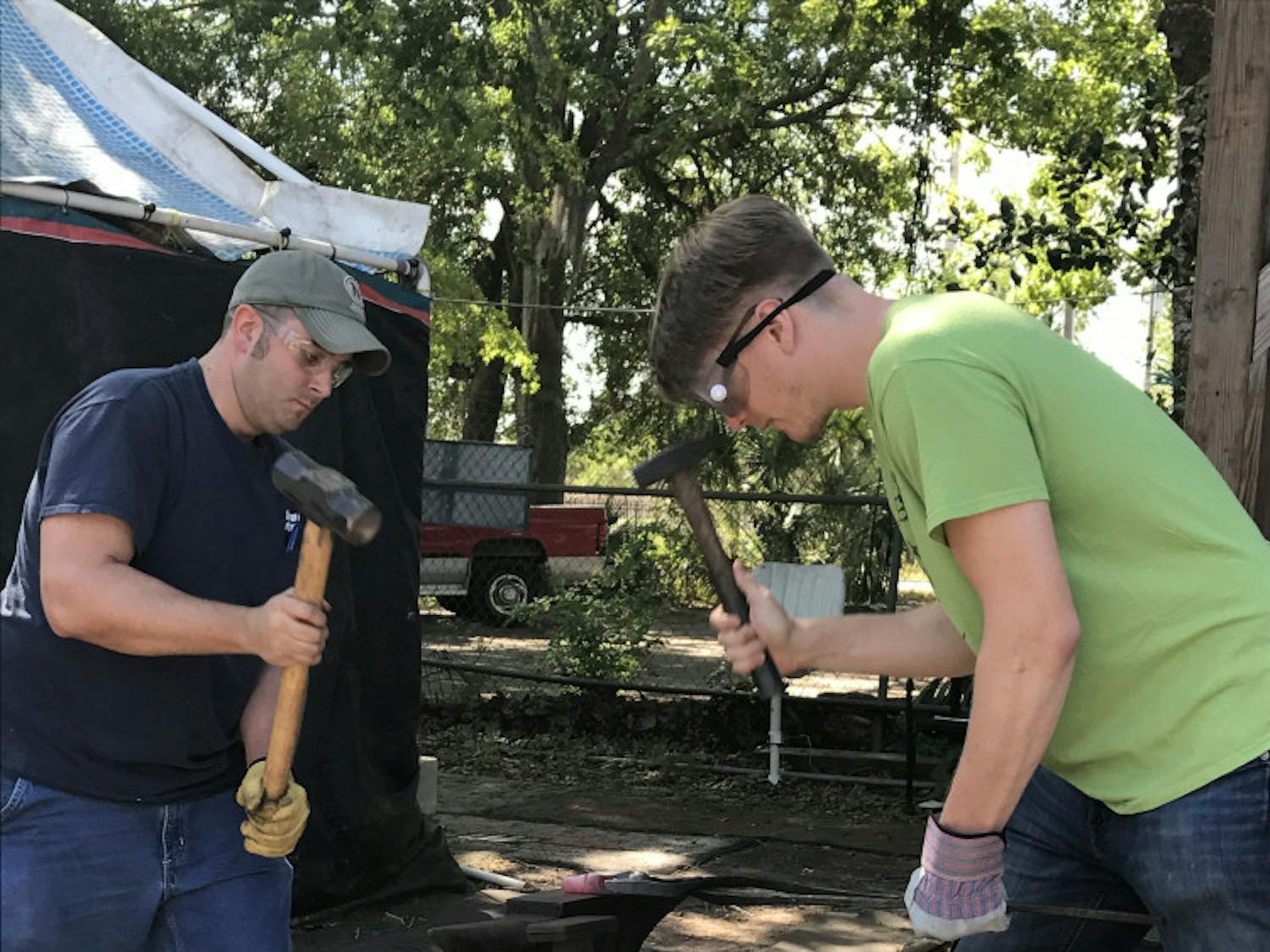 Thirty-one-year-old John Carter (left) and 26-year-old Martin Kipp team up to mold their mall pein hammer into an axe using a technique called forging.