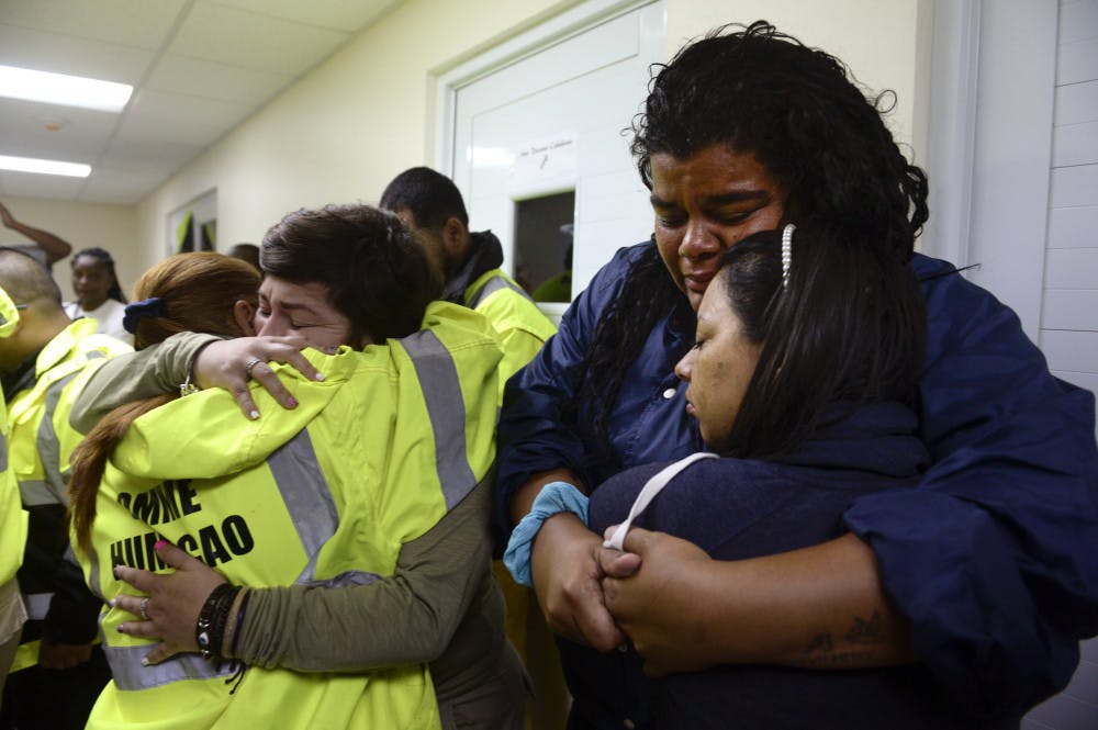 From left: Rescue team members Candida Lozada, Stephanie Rivera, Mary Rodriguez and Zuly Ruiz embrace as they wait to assist in the aftermath of Hurricane Maria in Humacao, Puerto Rico, on Wednesday.