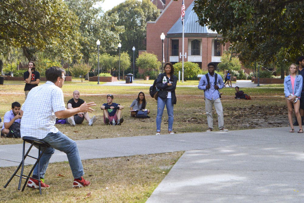 Tom Short and representatives from Gator Christian Life hold a conversation on the Plaza of the Americas with students about Christianity and evolution Wednesday afternoon. The plaza is one of UF’s free speech zones where controversial topics such as this can be discussed.&nbsp;