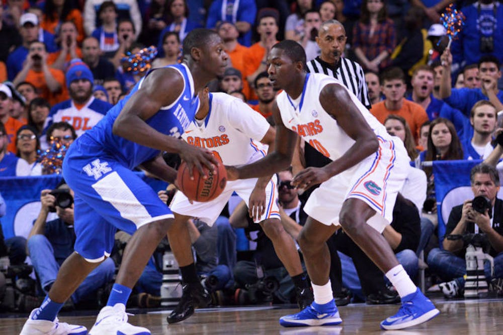 <p>Dorian Finney-Smith (right) guards Kentucky's Julius Randle during the Gators' 61-60 win against the Wildcats on March 16 in the Georgia Dome in Atlanta.</p>