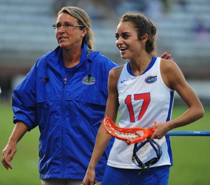 Lacrosse coach Amanda O’Leary walks off the field with junior Haydon Judge during halftime of a game against Dartmouth on March 20. O’Leary and the Gators beat Stony Brook 16-9 on Wednesday afternoon.