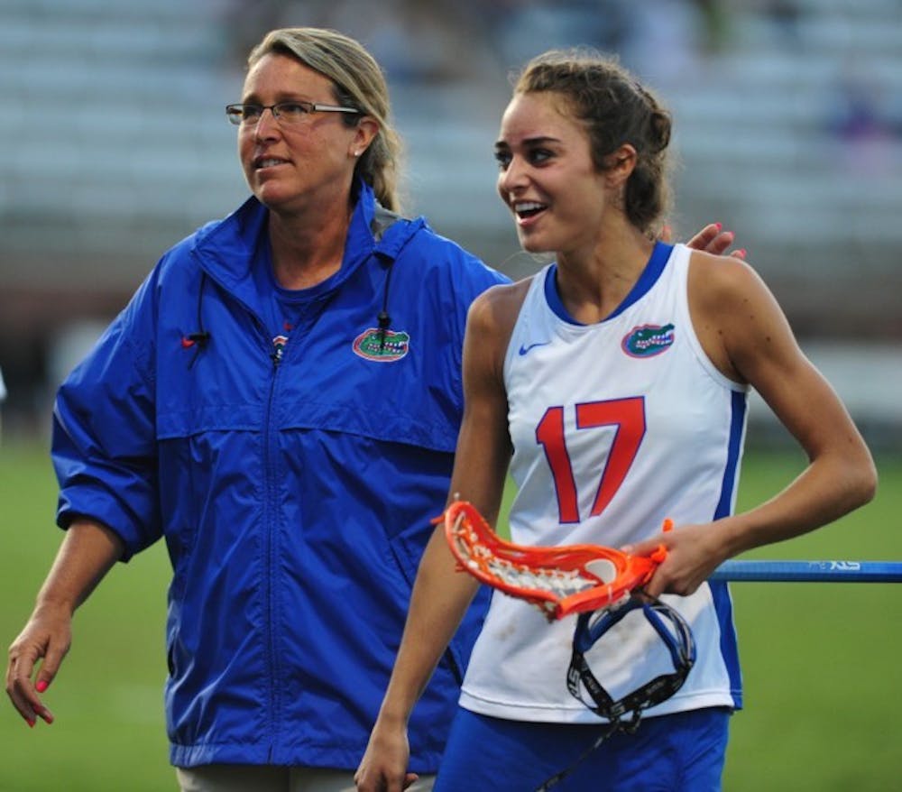 <p>Lacrosse coach Amanda O’Leary walks off the field with junior Haydon Judge during halftime of a game against Dartmouth on March 20. O’Leary and the Gators beat Stony Brook 16-9 on Wednesday afternoon.</p>