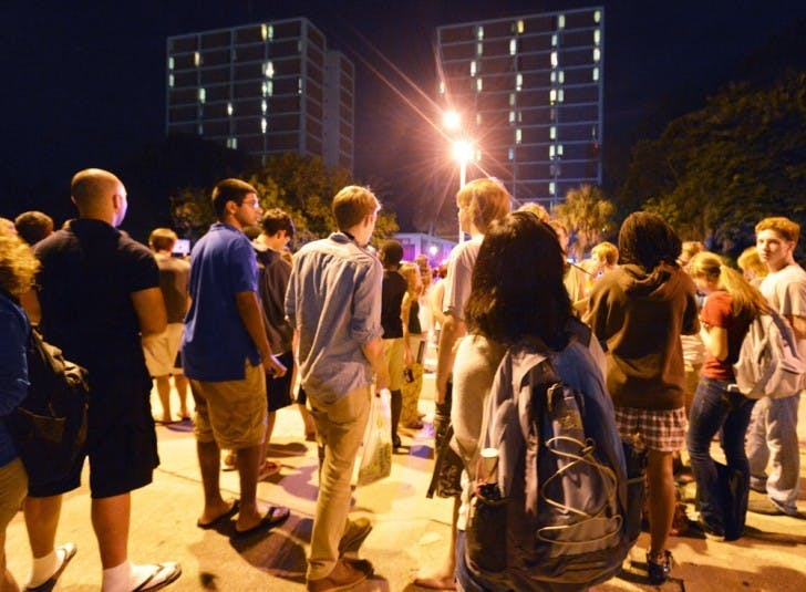 Students stand on Museum Road outside Beaty Towers on Monday night after they evacuated due to a fire alarm caused by a stove fire on the sixth floor of Beaty East.