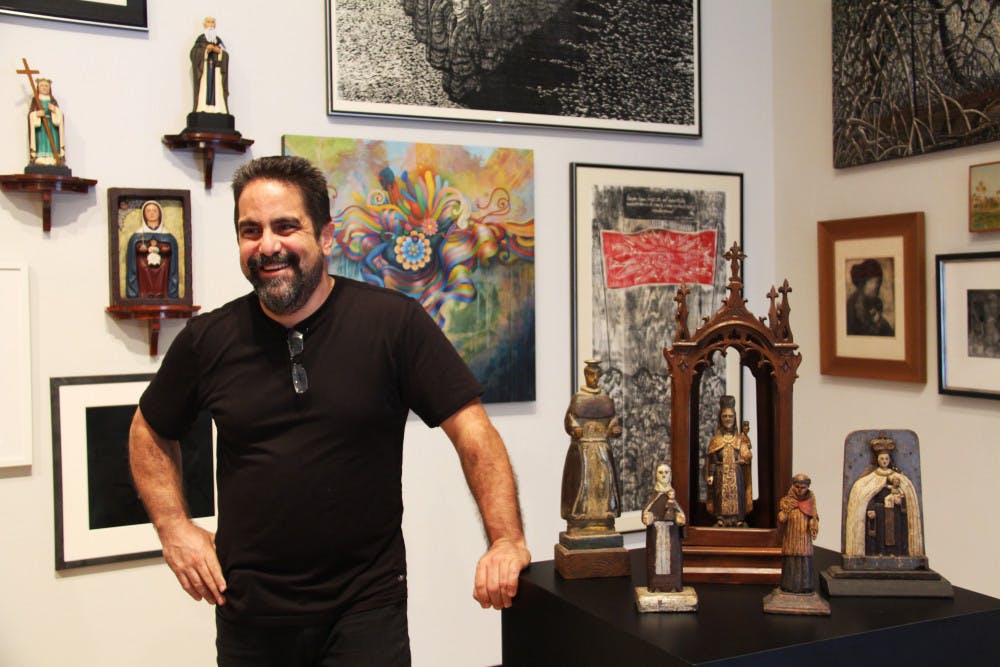 <p>Hector Puig stands with some of the pieces of his collection in the University Gallery.</p>