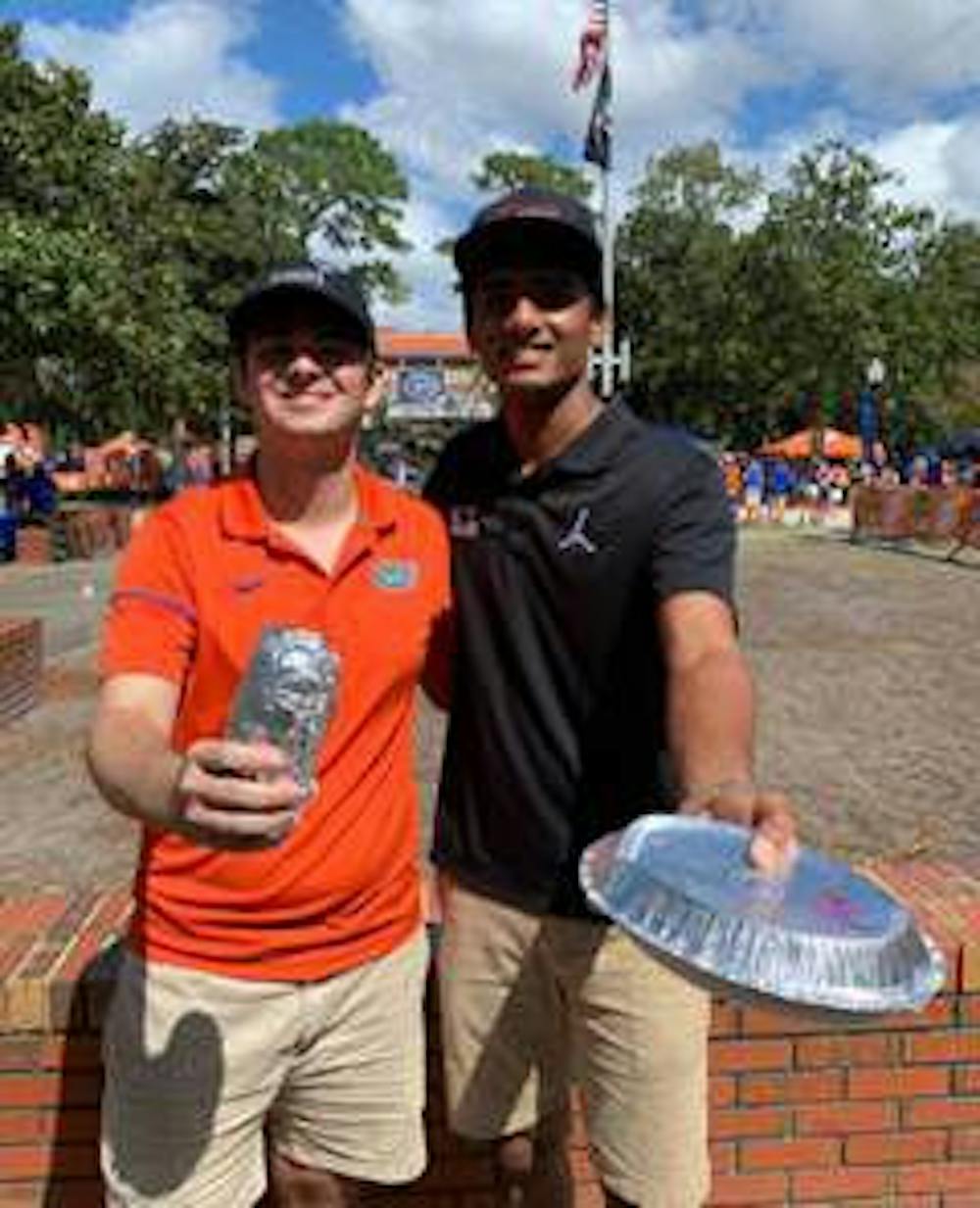 <p><span>Pawan Badisa (right) poses with the Chipotle given to him at Century Tower after his sign was shown on ESPN's College GameDay. He received a DM from Chipotle letting him know his order was waiting for him at the tower and that he would be given free Chipotle for a year.</span></p>