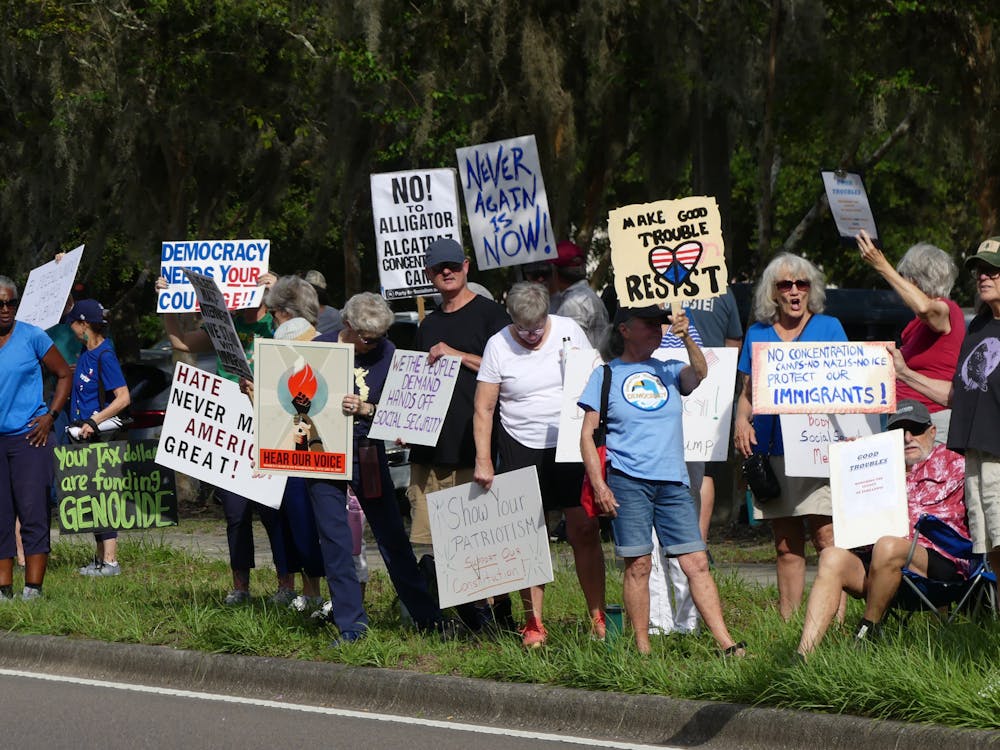 Protesters stand outside of Fred Cone Park on Thursday, July 17, 2025. 