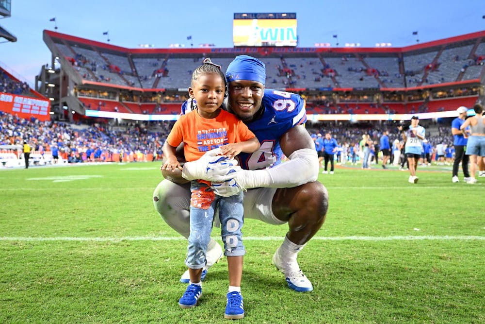 Florida Gators edge rusher Tyreak Sapp (94) stands with his daughter after a football game between the Texas Longhorns and the Florida Gators on Saturday, Oct. 4th, 2025, at Ben Hill Griffin Stadium in Gainesville, Fla.