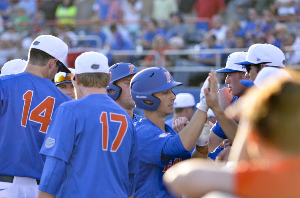 <p>Third baseman Jonathan India (center) celebrates with teammates after India hit a sacrifice fly in the fourth inning of Florida's 8-4 win on Feb. 20, 2016. India was one of three freshmen to start at least one game in the Gators' opening weekend series against Florida Gulf Coast. Eight freshmen made at least one appearance over the three days.</p>