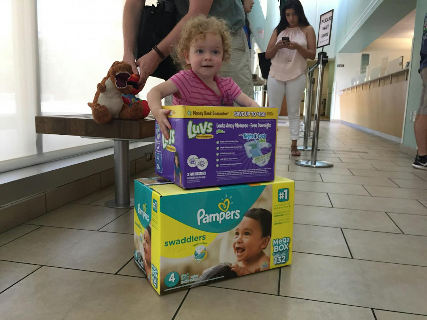 Two-year-old Isobel Vincent picks up a box of diapers at the UF Transportation and Parking Services office Wednesday afternoon. Employees donated two boxes of diapers to her and her parents after her father, Michael Vincent, a 33-year-old UF PhD musicology candidate, tweeted at UF President Kent Fuchs about the “Food for Fines” program.