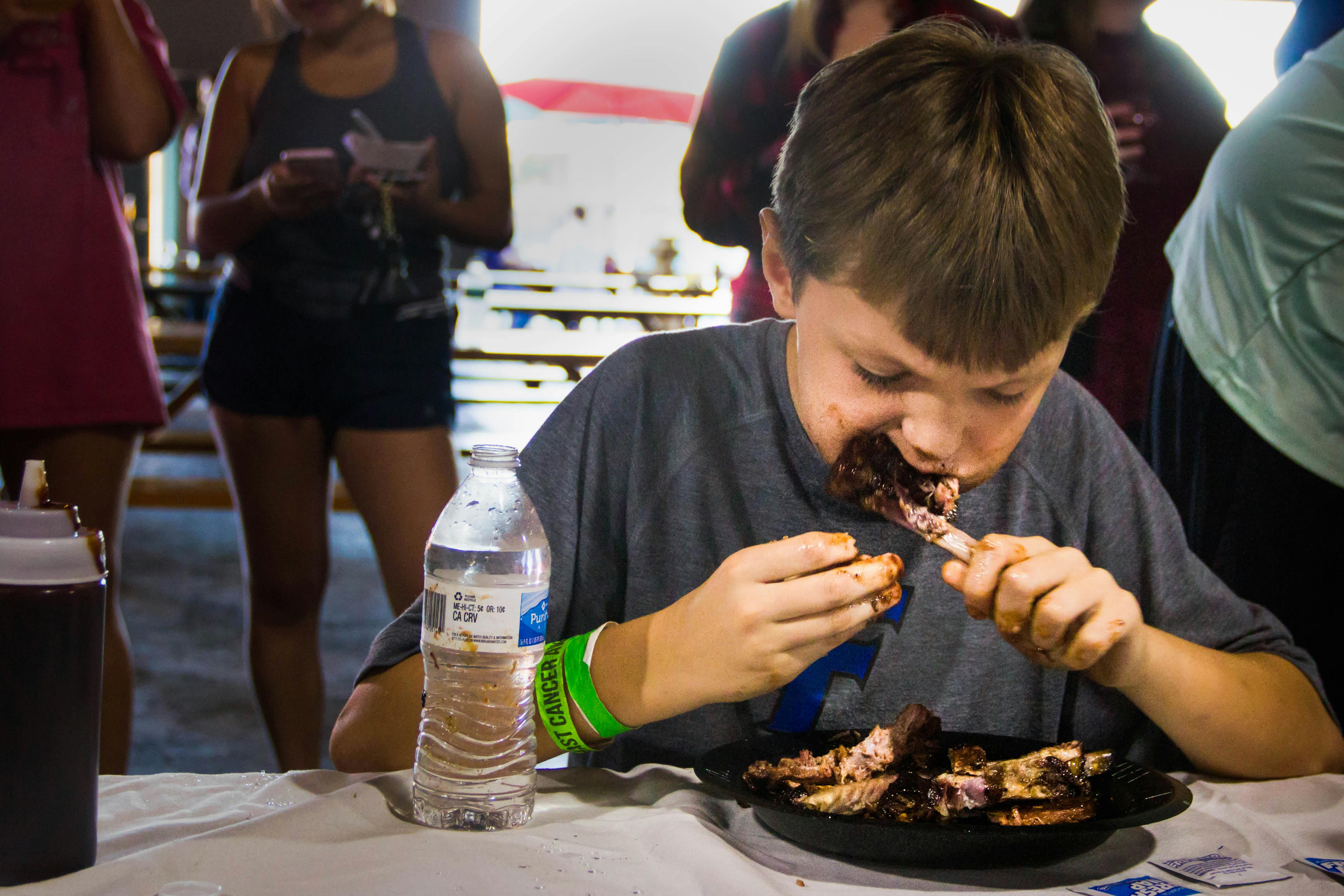 Ten-year-old Taylor Brewer competes in the annual Adam’s Rib Co. Charity Rib Eating Contest Sunday at the First Magnitude Brewing Co. “He’s fired up and has been talking about it all day,” said his mother and co-owner of Adam’s Rib Co., Michele Brewer.