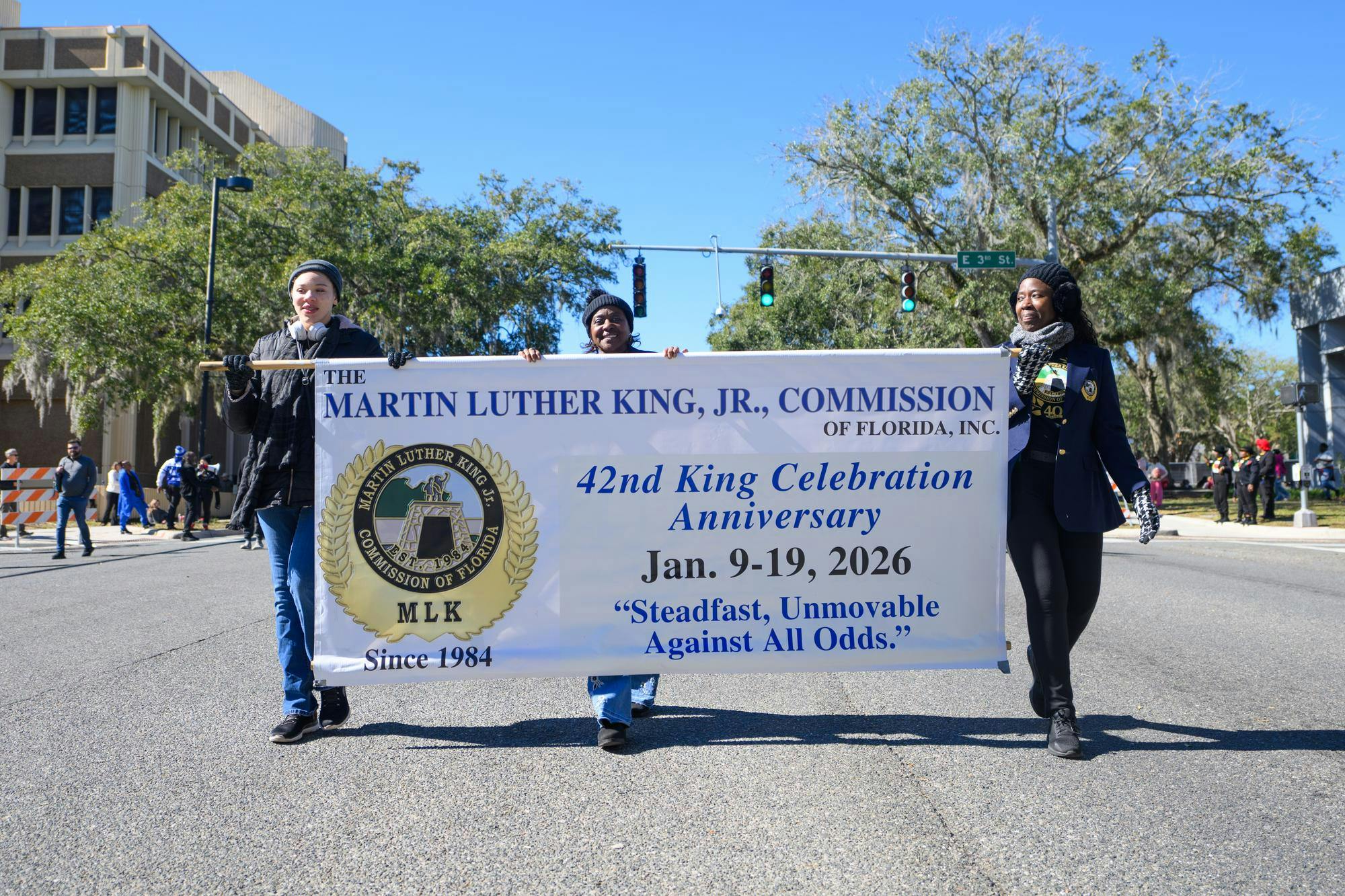Parade participants carry a sign for The Martin Luther King, Jr., Commission of Florida as they lead Gainesville's MLK Day Parade, Monday, Jan. 19, 2026.