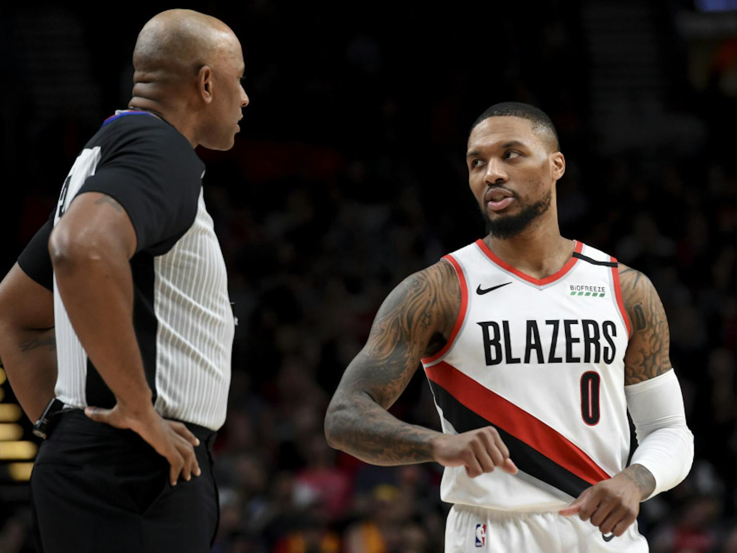 Portland Trail Blazers guard Damian Lillard, right, speaks with referee Kevin Cutler, left, during the first half of an NBA basketball game against the Utah Jazz in Portland, Ore., Saturday, Feb. 1, 2020. (AP Photo/Steve Dykes)