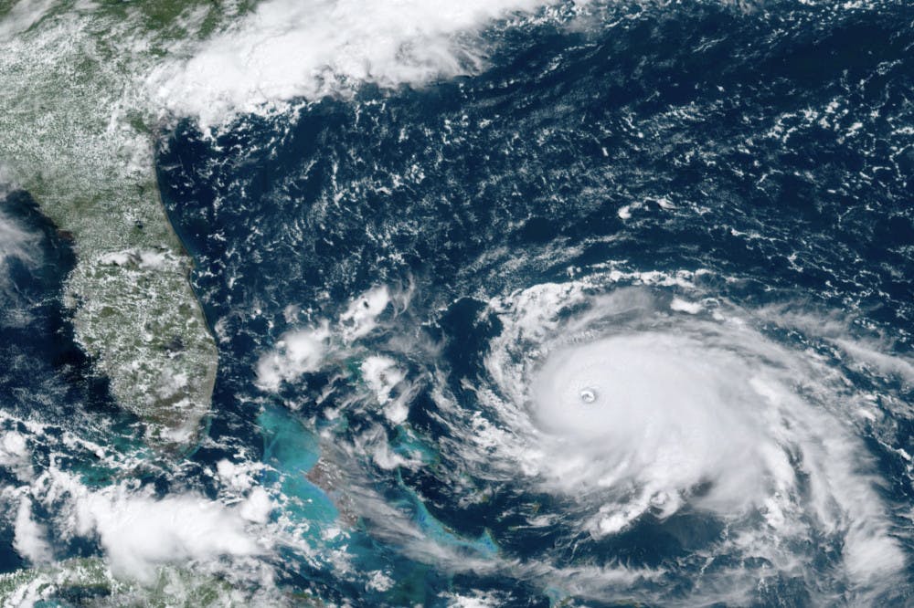 This GOES-16 satellite image taken Saturday, Aug. 31, 2019, at 16:00 UTC and provided by National Oceanic and Atmospheric Administration (NOAA), shows Hurricane Dorian, right, churning over the Atlantic Ocean. Hurricane Dorian bore down on the Bahamas as a fierce Category 4 storm Saturday, with new projections showing it curving upward enough to potentially spare Florida a direct hit but still threatening parts of the Southeast U.S. with powerful winds and rising ocean water that causes what can be deadly flooding.(NOAA via AP)
