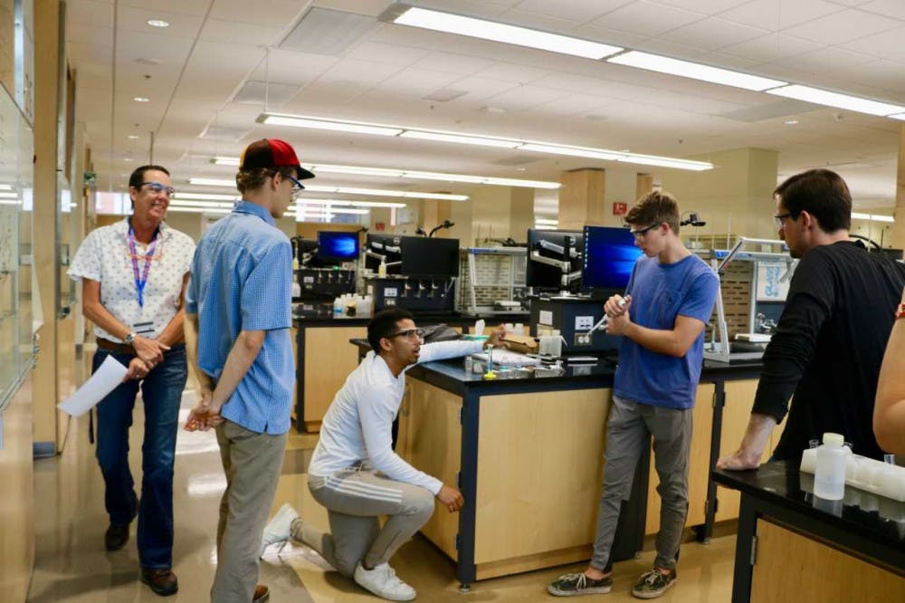 Students conducting their chemistry lab in-person for two weeks with Candace Biggerstaff (far left), the teaching lab specialist for Chemistry I.
