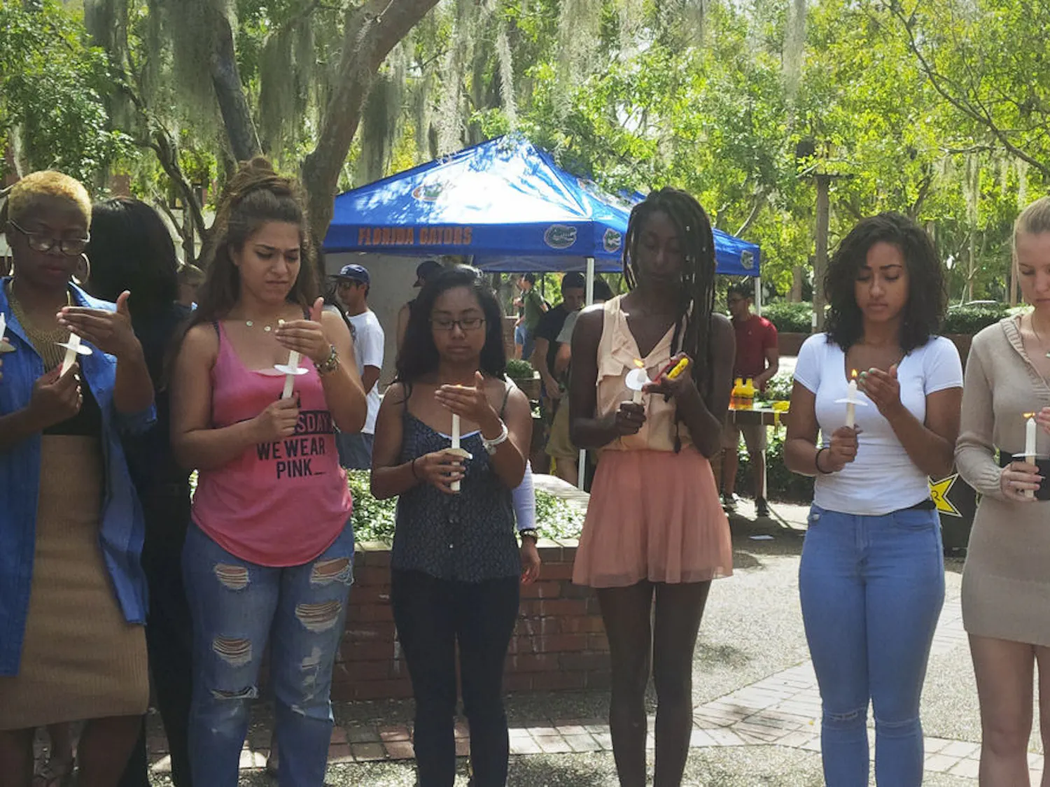 Students hold candles on Turlington Plaza at a vigil on Oct. 9, 2015, for the victims of the Oct. 1 shooting at Umpqua Community College in Oregon. Roo Poage, right, a 19-year-old UF architecture sophomore, said she was terrified when she first heard about the shooting because her close friend lives near the college.