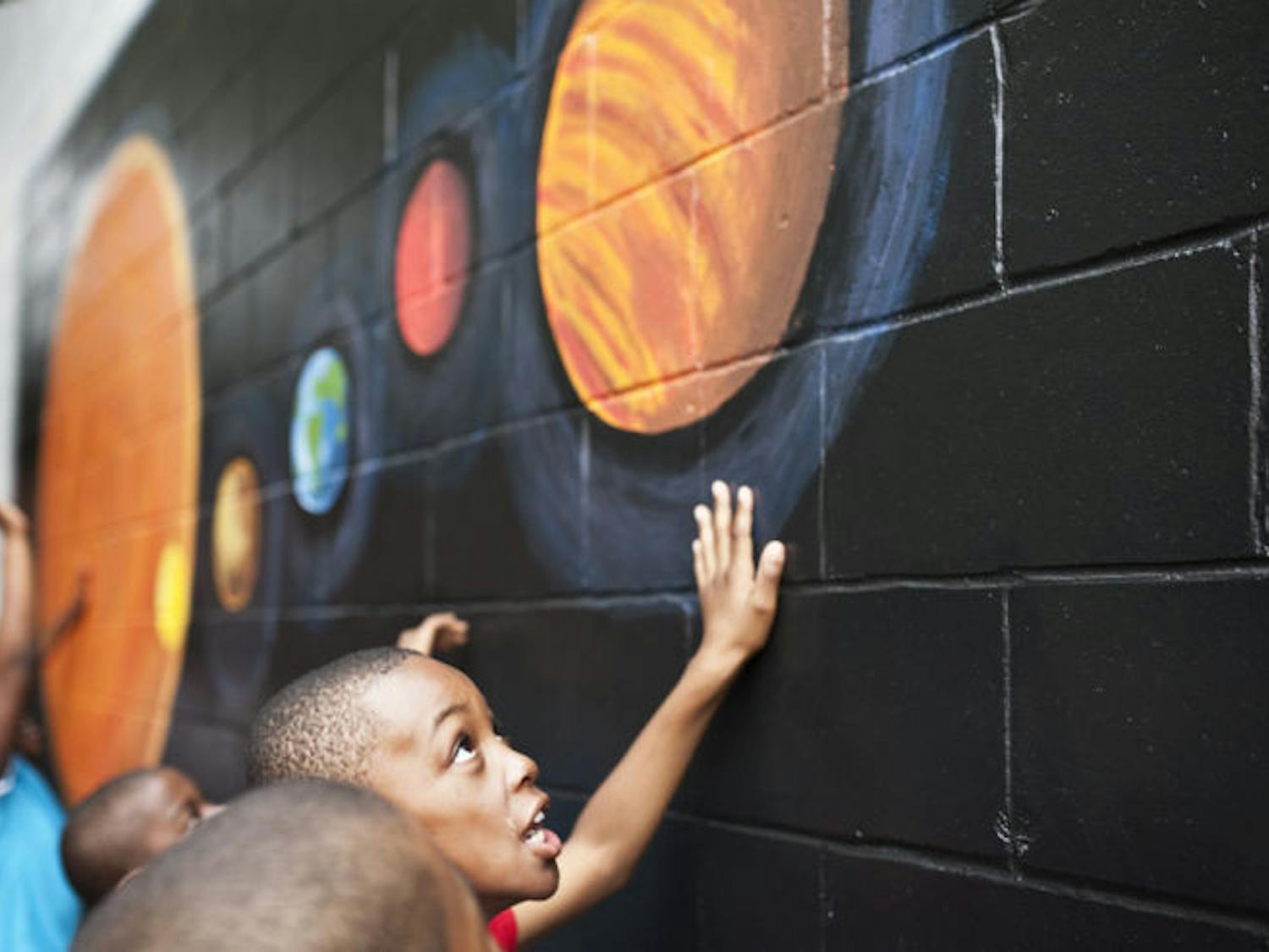 Idylwild Elementary School students react to the new improvements made to their school Monday morning. Volunteers with Project Makeover spent this past weekend painting murals and installing a new playground. Idylwild Elementary raised $21,000 for the renovations through fundraisers and donations.