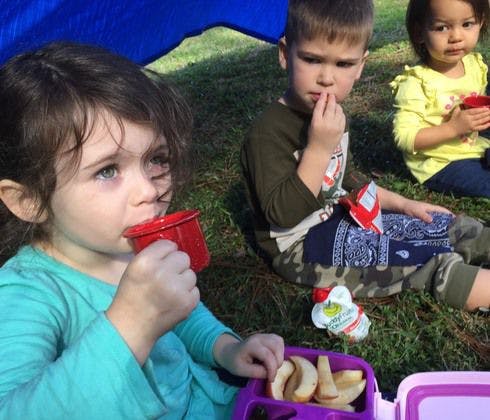 Emme, 4, and her friend, Colton, drink hot blueberry tea during snack time at Northeast Park during Tinkergarten class. Tinkergarten is a play-based learning program where groups of parents and children are encouraged to play outdoors, exploring the world around them through guided activities that teach core life skills.