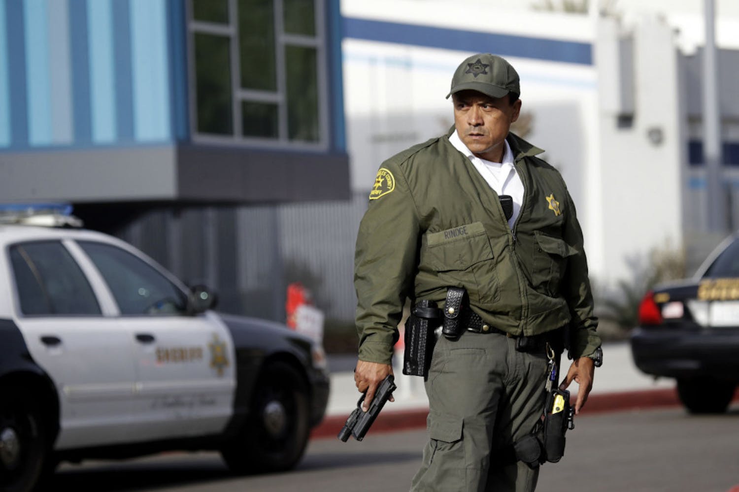 A member of the Los Angeles County Sheriff Department stands outside of Saugus High School with his weapon drawn after reports of a shooting on Thursday, Nov. 14, 2019, in Santa Clarita, Calif. (AP Photo/Marcio Jose Sanchez)