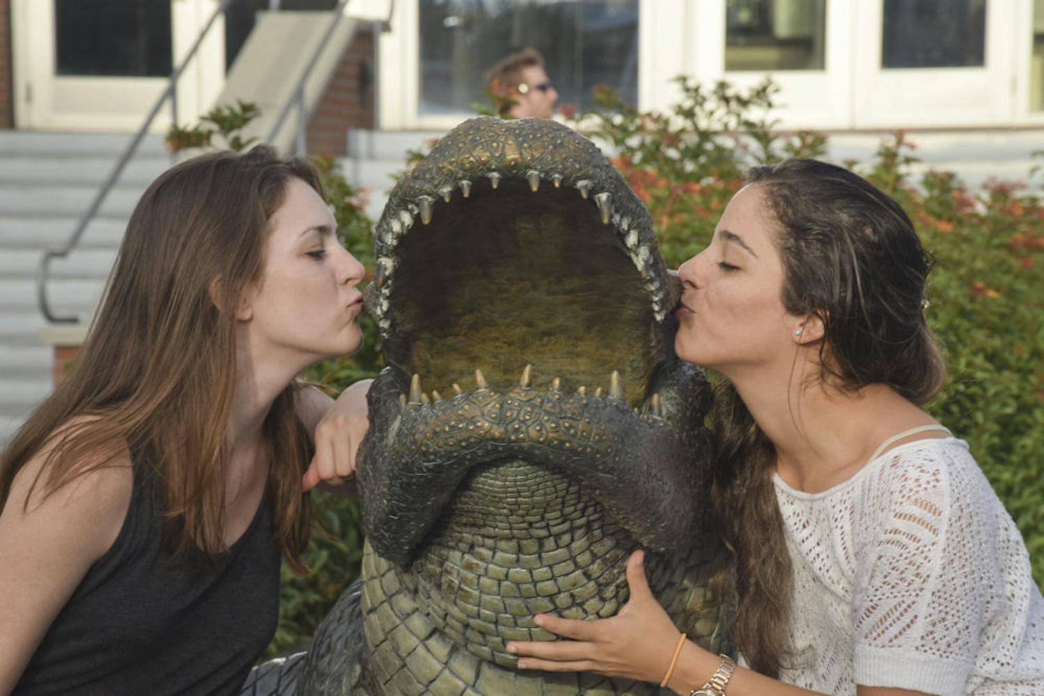 Sydney Folsom, left, 23, and Sophia Saportas, 24, both UF civil engineering seniors, pose with the Bull Gator statue outside Ben Hill Griffin Stadium. Saportas said she’s very happy to finish her university years. “It’s about time,” Folsom said.