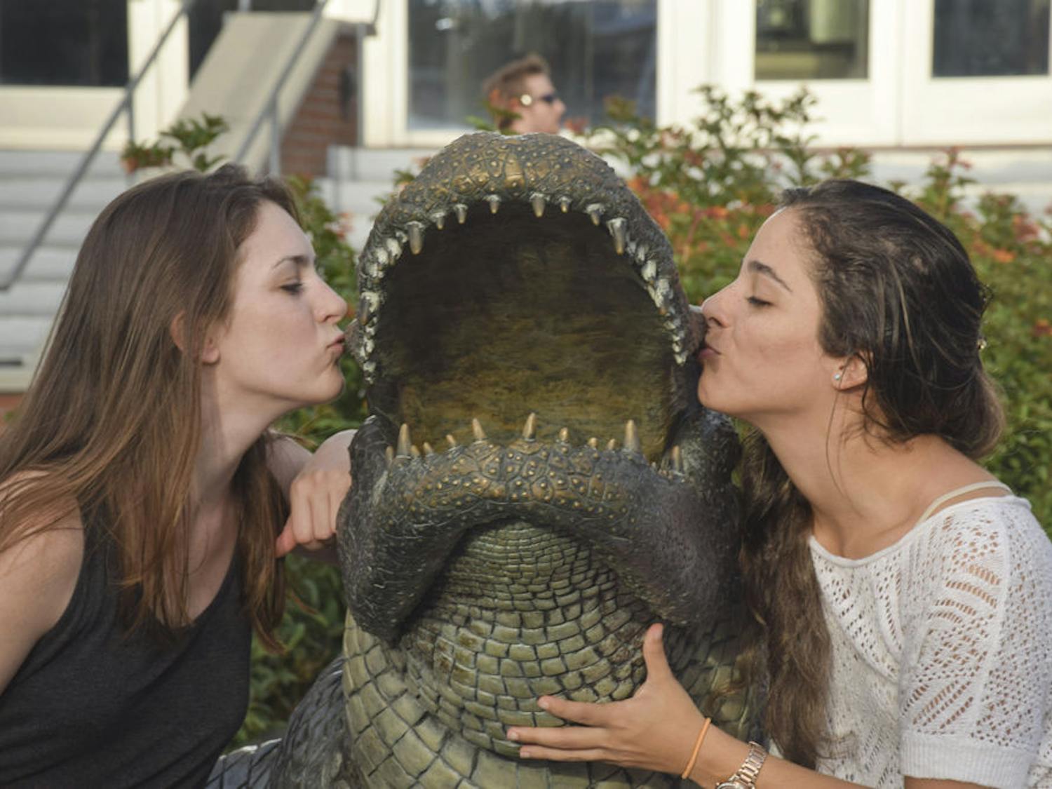 Sydney Folsom, left, 23, and Sophia Saportas, 24, both UF civil engineering seniors, pose with the Bull Gator statue outside Ben Hill Griffin Stadium. Saportas said she’s very happy to finish her university years. “It’s about time,” Folsom said.