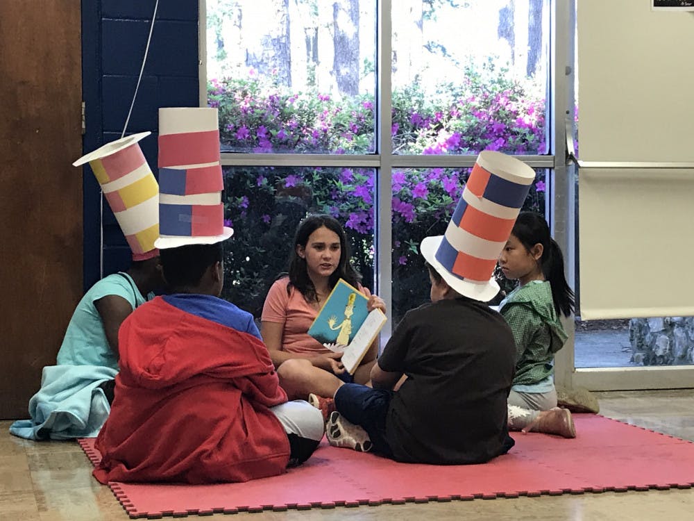 Fourth grader Brianna Smith holds out a Dr. Seuss book to show the picture to other kids in her after-school program.