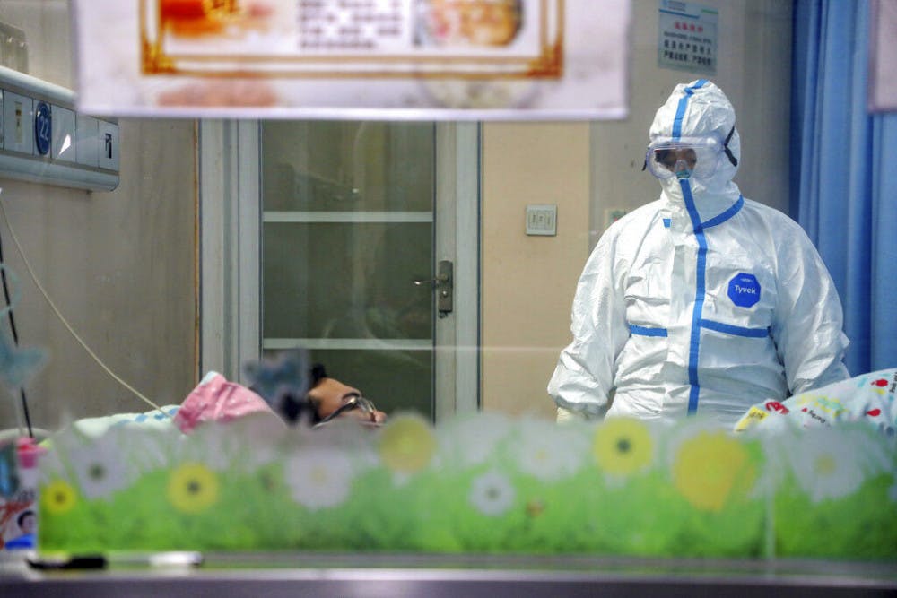 A doctor attends to a patient in an isolation ward at a hospital in Wuhan in central China's Hubei Province, Thursday, Jan. 30, 2020. China counted 170 deaths from a new virus Thursday and more countries reported infections, including some spread locally, as foreign evacuees from China's worst-hit region returned home to medical observation and even isolation.