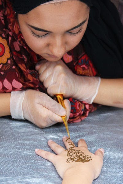 Emana Sheikh, a UF nutrition sophomore, gives a student a Henna tattoo on the Plaza of the Americas on Tuesday afternoon.&nbsp;