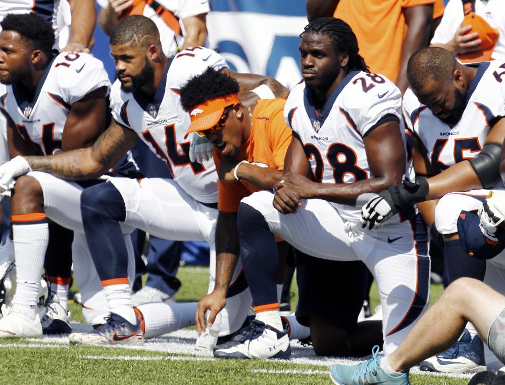 Denver Broncos players, including Jamaal Charles (28) kneel during the national anthem prior to an NFL football game against the Buffalo Bills, Sunday, Sept. 24, 2017, in Orchard Park, N.Y. (AP Photo/Jeffrey T. Barnes)