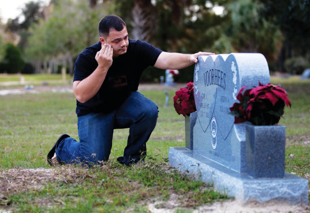<p>Joshua Voorhees, a 27-year-old supervisor for Neighborhood Storage in Ocala, visits his grandfather’s grave Thursday evening. Gary Voorhees died from cancer at age 75.</p>